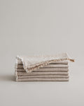 Stack of CULTIVER Fia Napkins in natural linen, soft and textured table linen for elegant dining settings.