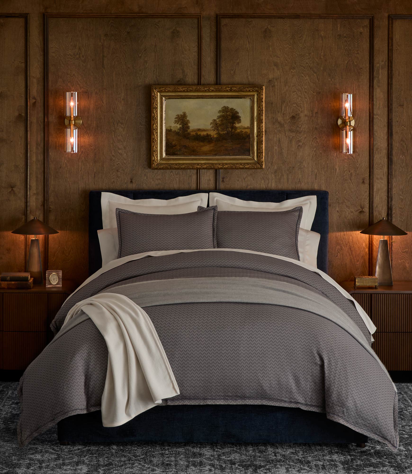 Savoy Jacquard Duvet Set styled in a bedroom on a bed with a dark upholstered headboard, Navy