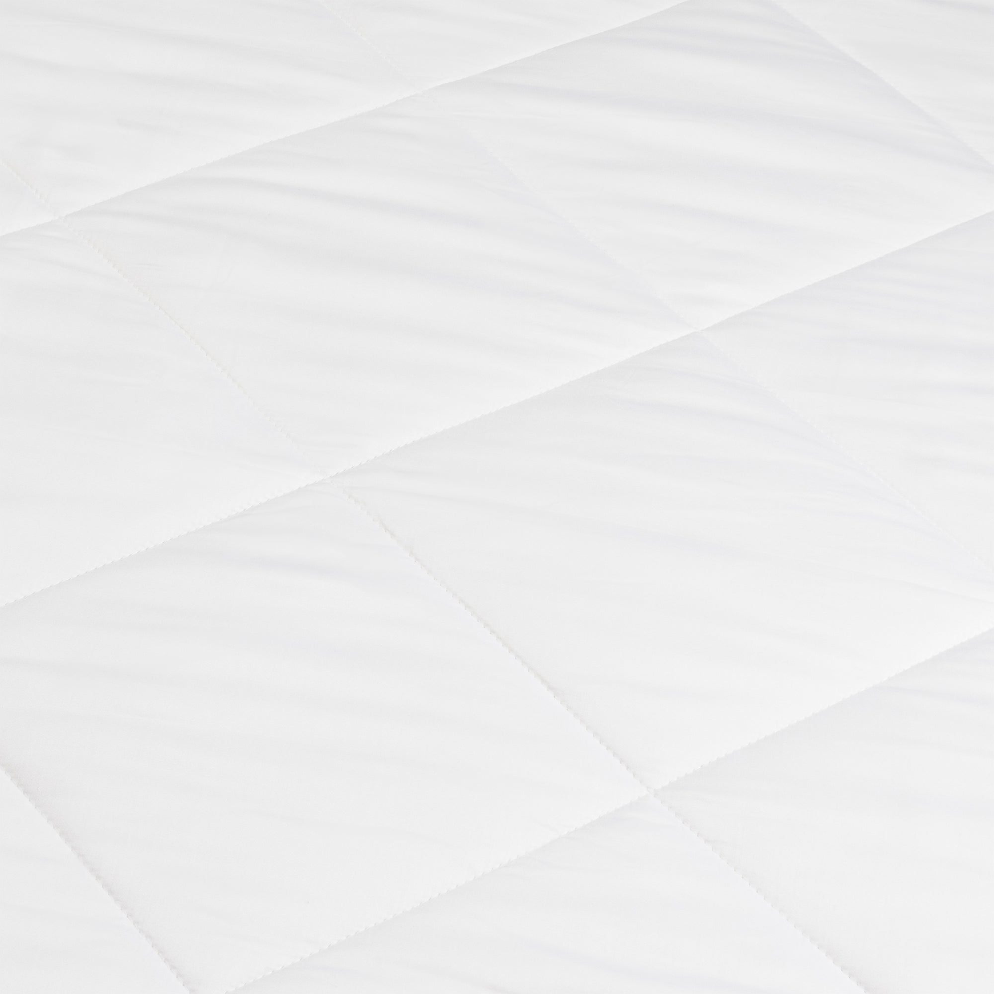 A close-up of the Cozy Earth Bamboo Viscose Comforter shows its smooth, soft white quilted fabric with a diamond pattern formed by intersecting stitched lines.|Filling:Extra